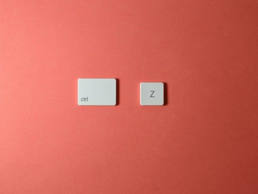 Close-up of 'Ctrl' and 'Z' keyboard keys on a vibrant coral background. Ideal for tech and design themes.