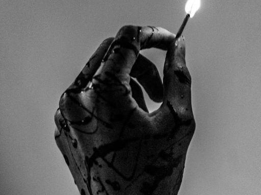 grayscale photo of person holding lighted match stick