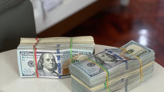 a stack of money sitting on top of a white table